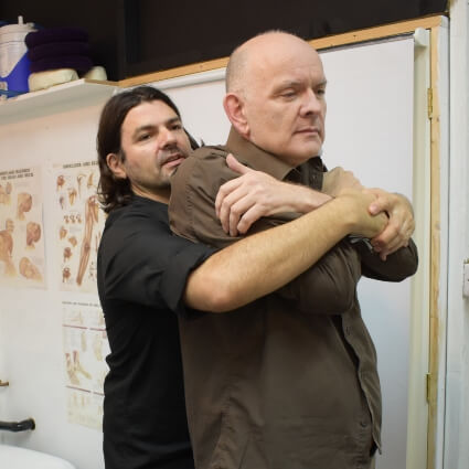 Dr Roddy assisting patient with elbow stretch