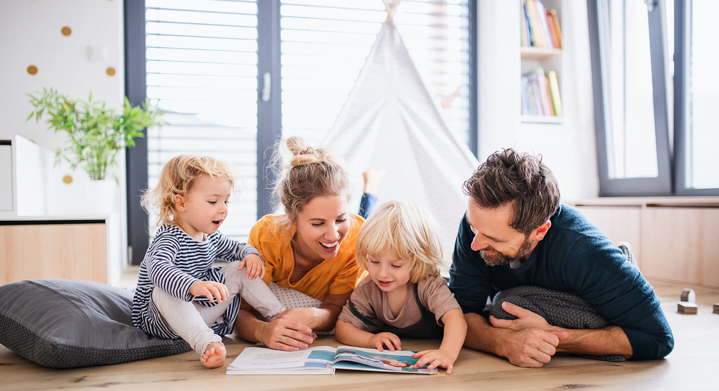 couple with their kids reading a book