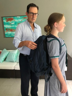 Dr Lanthois checks that his daughter Erika has her school backpack on correctly
