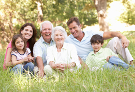 family smiling together sitting in grass