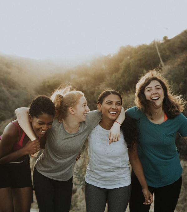 group of 4 women smiling outdoors