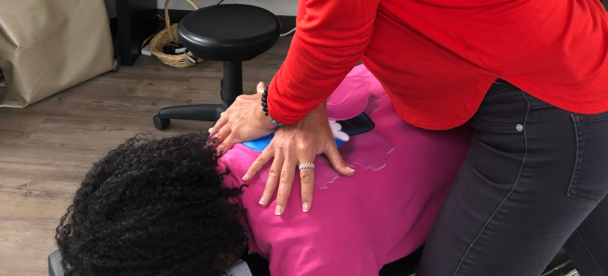 Female patient receiving an upper-back adjustment
