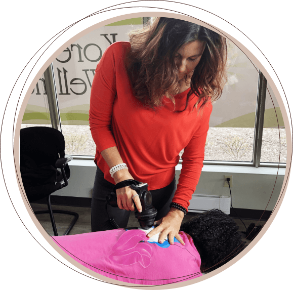 Dr. Nancy using a chiropractic tool to treat a patient