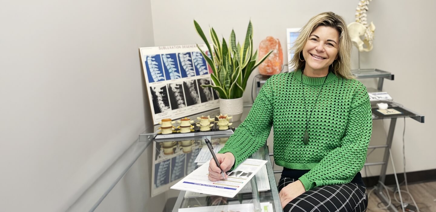 Mississauga chiropractor Dr. Nancy sitting at her desk