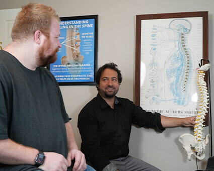 Dr Peter showing patient a spine model