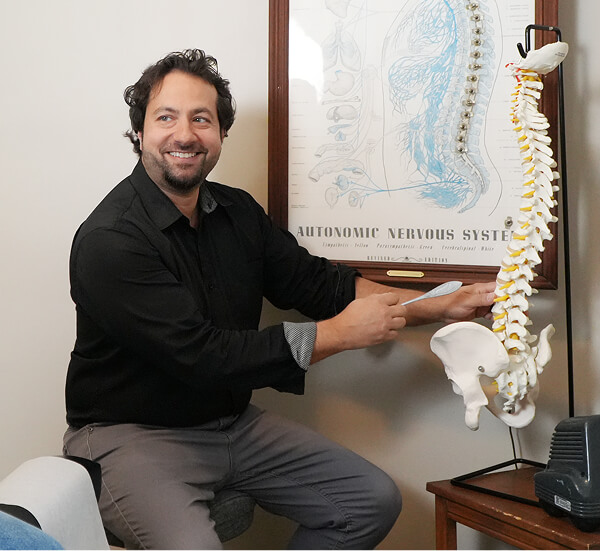 London chiropractor Dr Peter pointing at a spine model