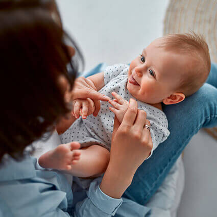 playful-baby-sticking-out-tongue-on-moms-lap-sq