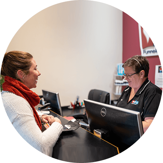 Receptionist greeting patient at front desk