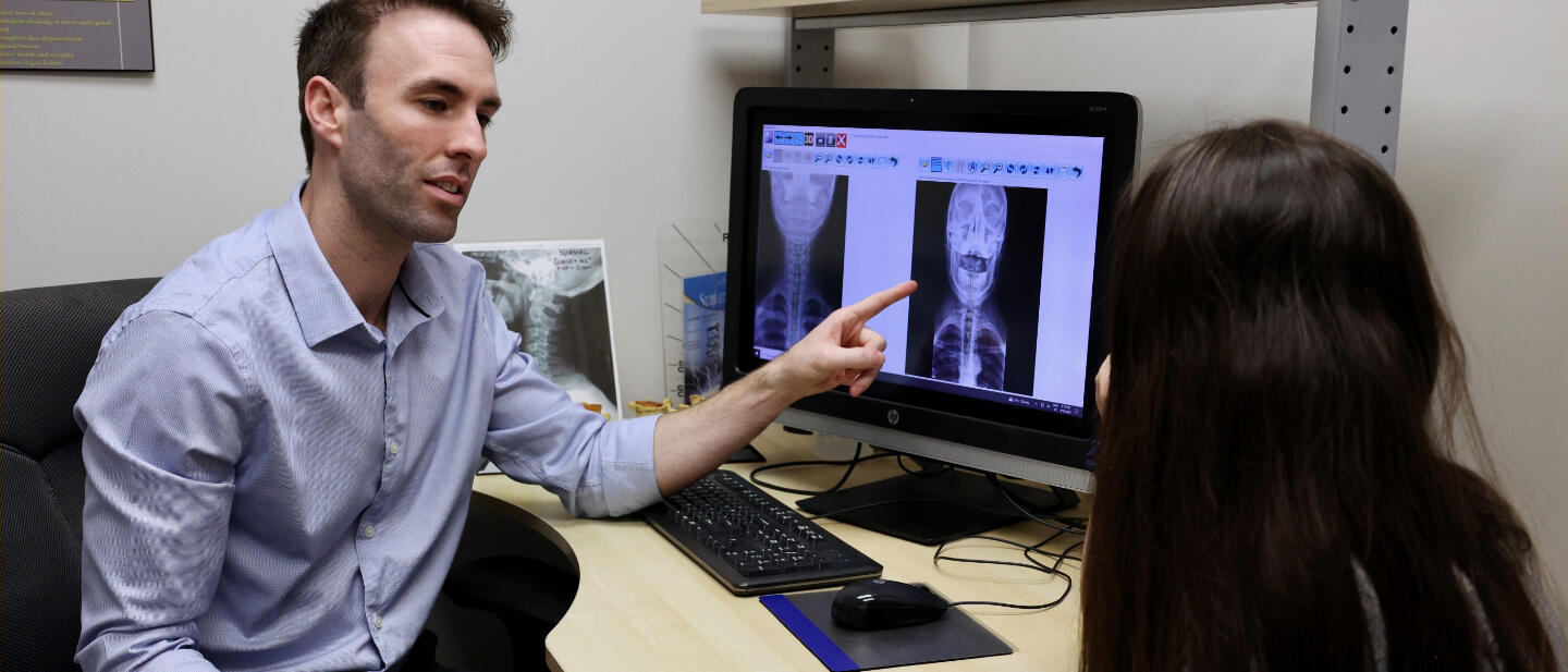 doctor pointing at xrays on screen