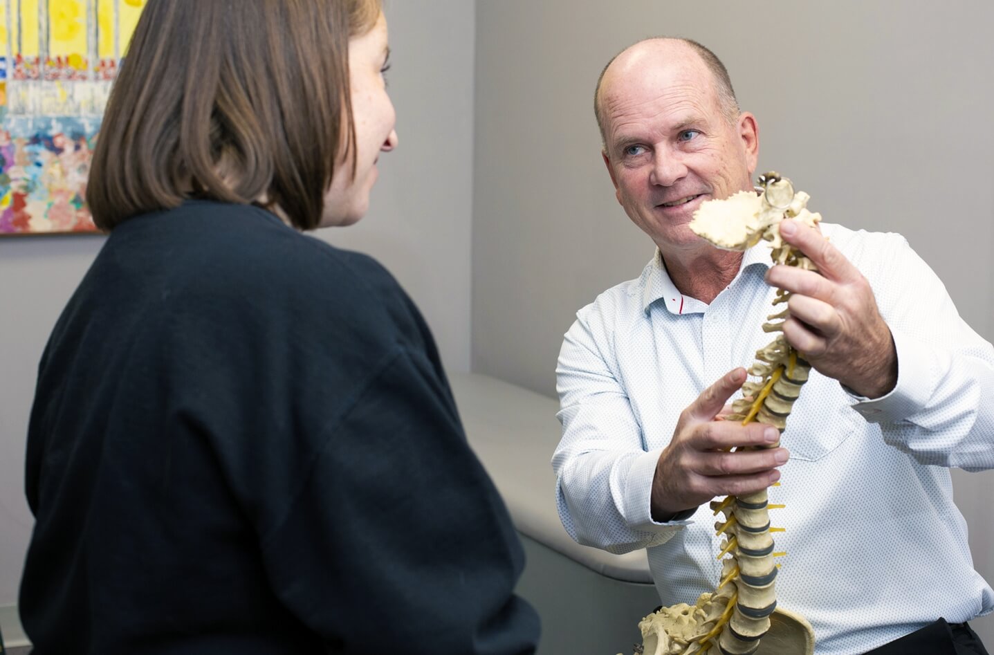 Prince Frederick chiropractor Dr Collins showing spine model to a patient