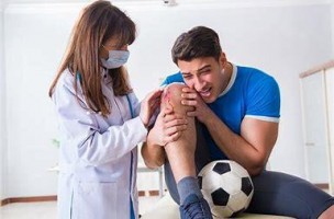 man with injured knee being examined by a doctor
