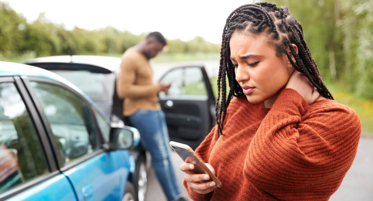 Woman busy on mobile phone after car crash