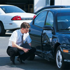 man looking at dented car door from car accident