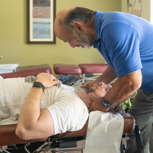 Male patient receiving a chiropractic neck adjustment