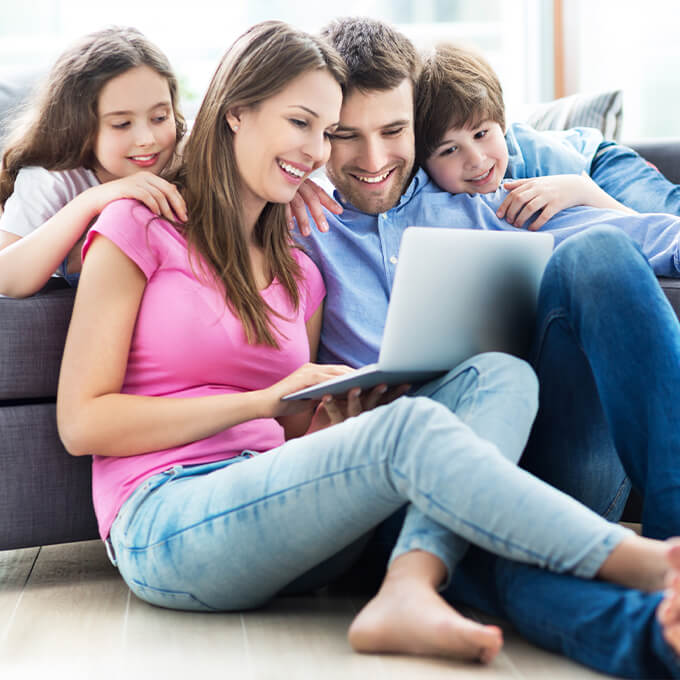 family looking at computer on couch