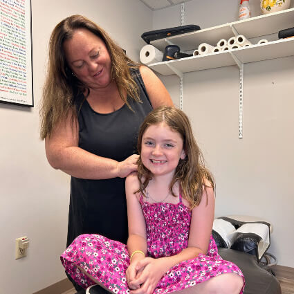 Weymouthj Chiropractor Dr. Diane Capone adjusting girl on table