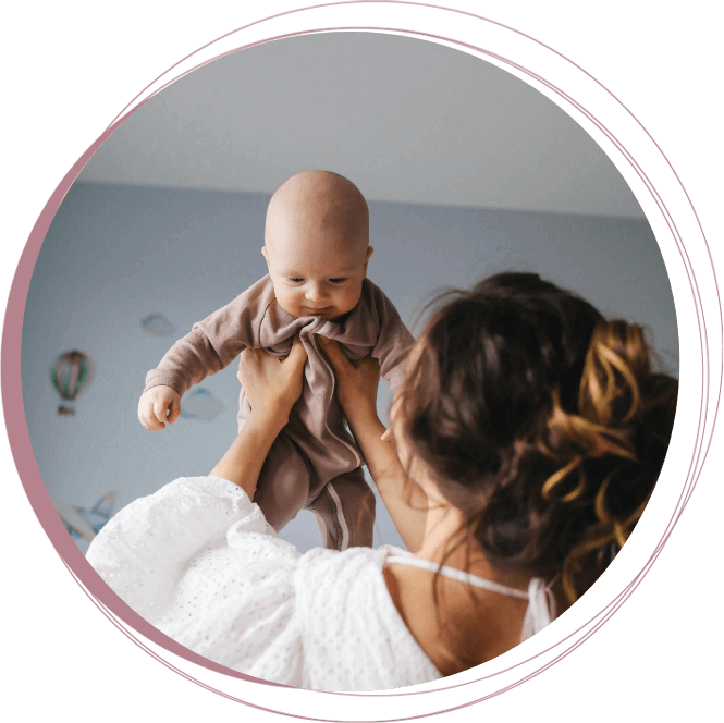 woman holding up tiny baby