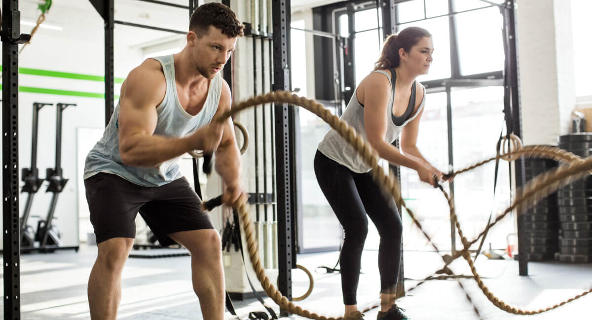 Man and woman exercising with ropes