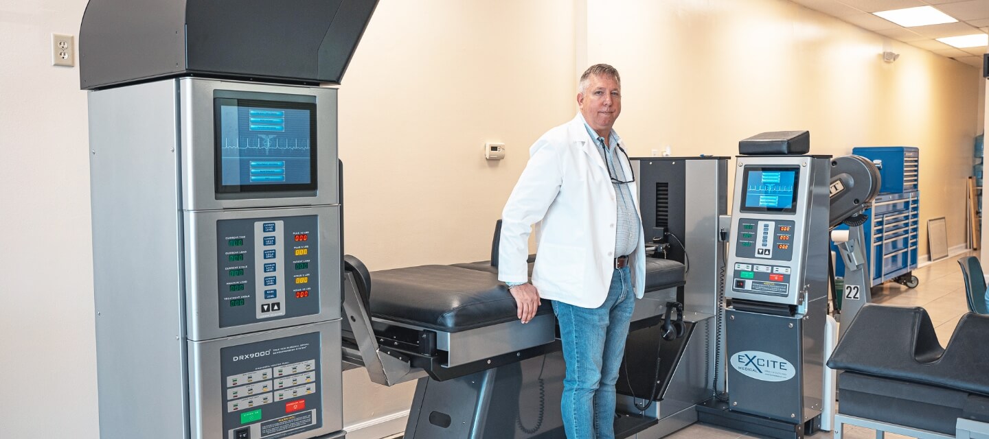 Dr Michael in front of adjustment machine