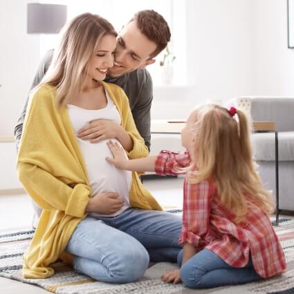 Pregnant lady with husband and child