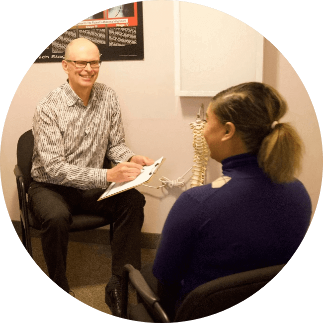 Mississauga chiropractor Dr. Tomlin in consultation with a female patient