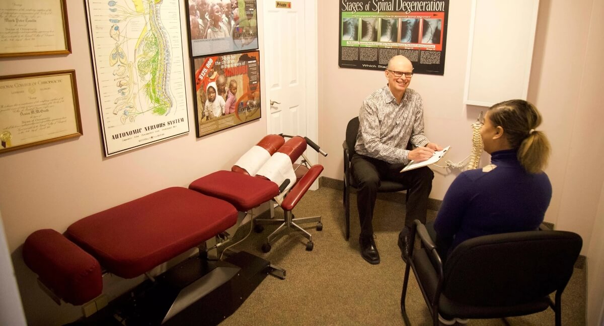 Dr. Mark Tomlin of Churchill Chiropractic in consultation with a female patient