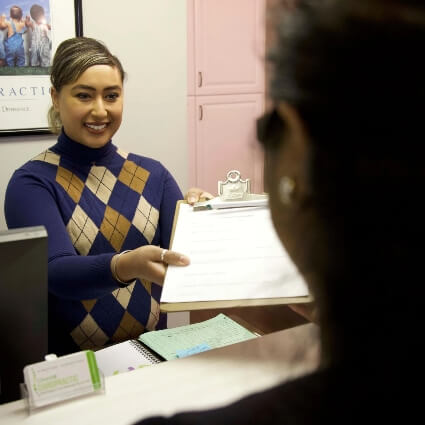 Churchill Chiropractic receptionist discussing paperwork with Mississauga patient