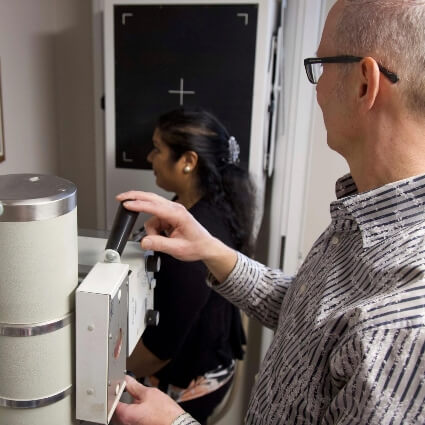 Mississauga chiropractor Dr. Mark Tomlin taking x-ray of female patient