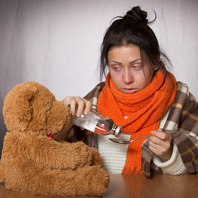 Woman with flu and bear toy