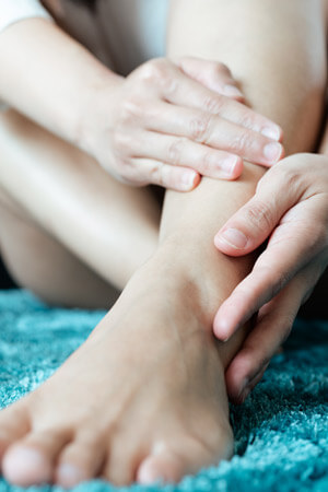 hands holding ankle in pain