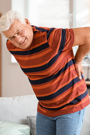 man holding lower back in pain