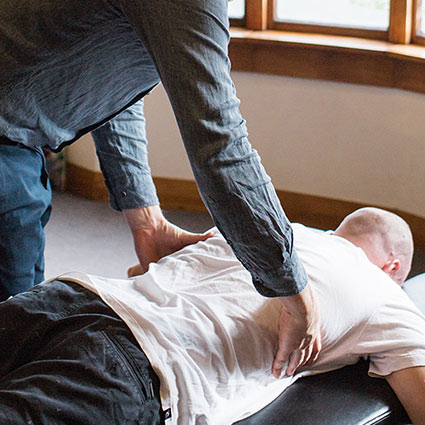 Chiropractor adjusting a man's back