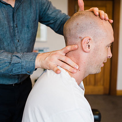 chiropractor adjusting a man's neck