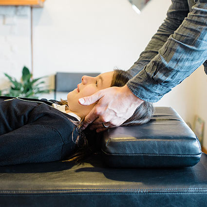 chiropractor adjusting a young girl's neck