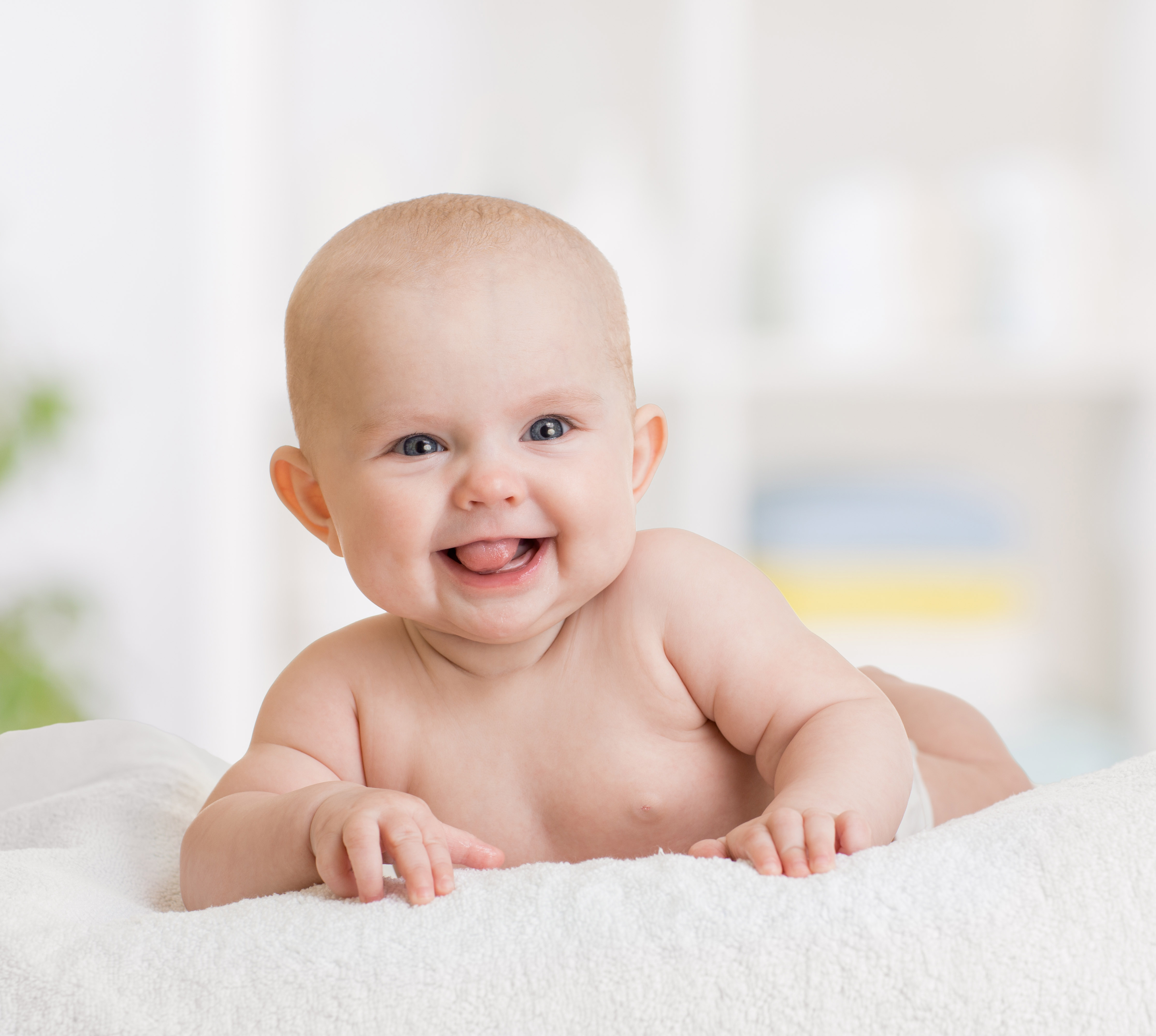 smiling baby girl lying on towel