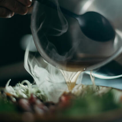 broth being poured into a bowl