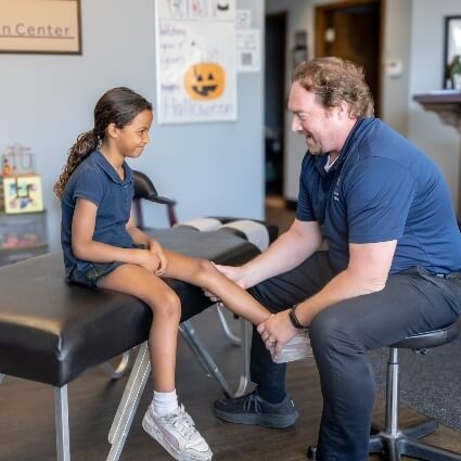 chiropractor adjusting childs leg