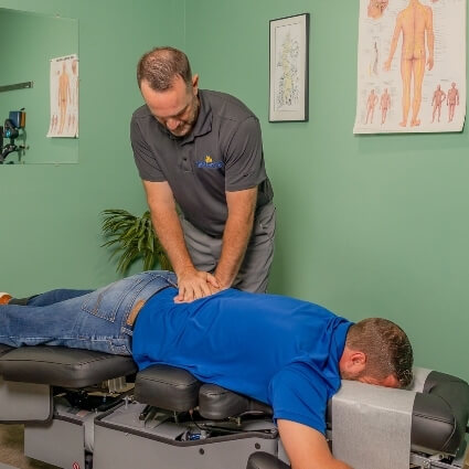 Dr. Kyle adjusting patients back