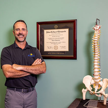 Dr. Buckle standing by spine model