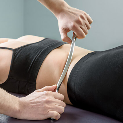 person having graston treatment done on their back