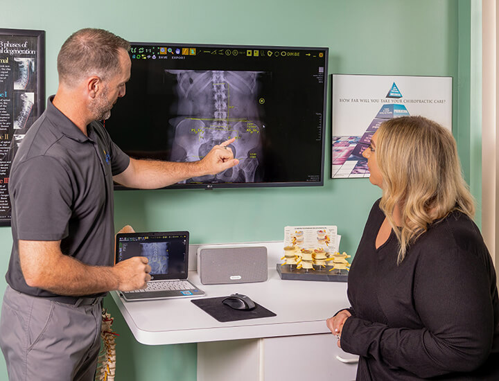 Chiropractor showing X-ray to patient