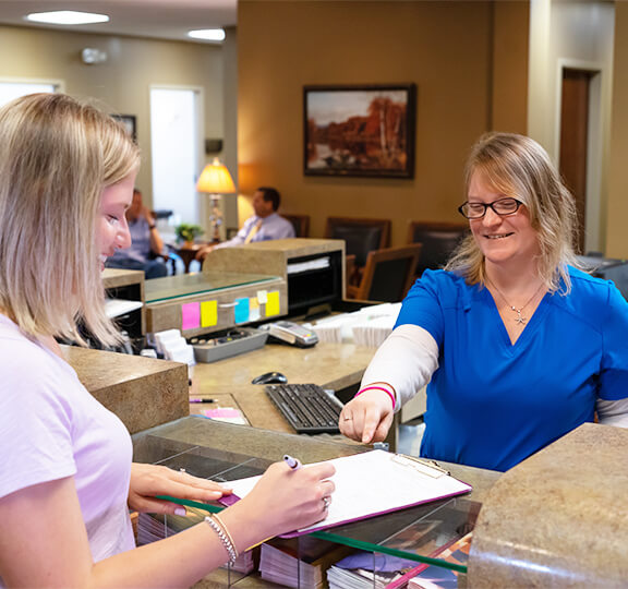 Staff handing paperwork to patient