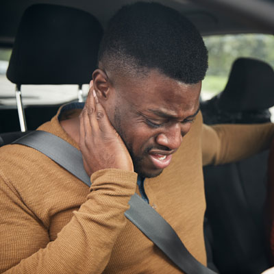 man with neck pain while driving