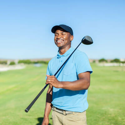 smiling man holding a golf club