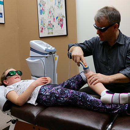 Dr Chris performing laser therapy on a patient