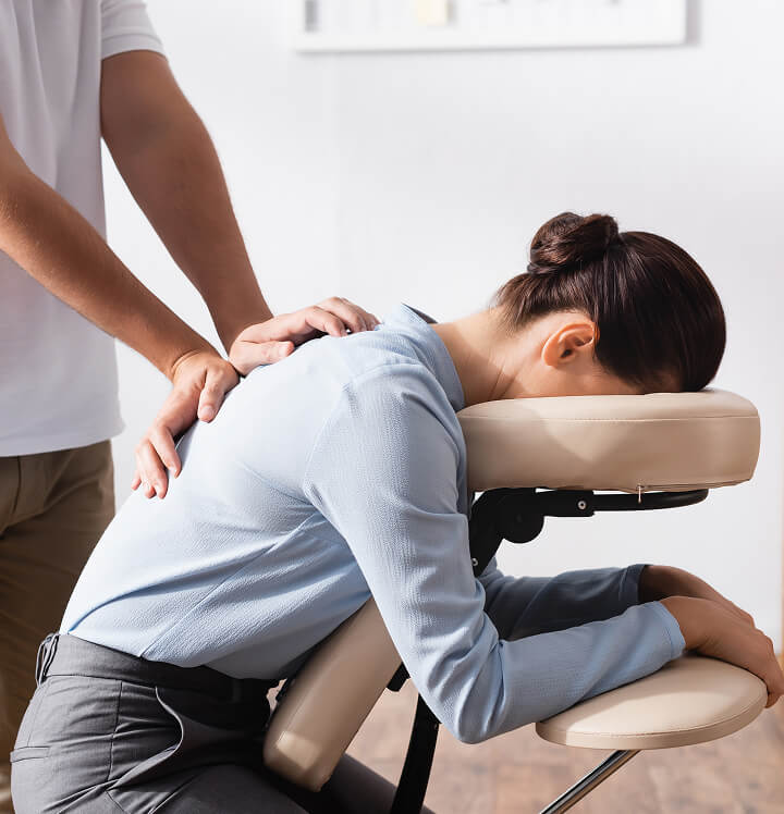 patient on massage chair having back examined