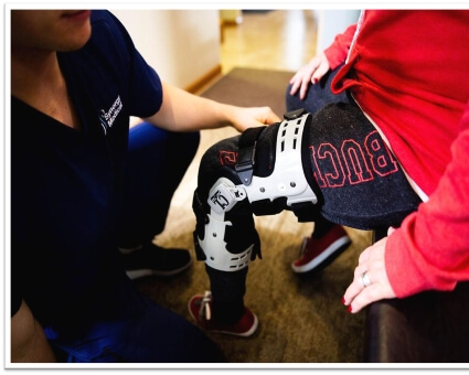 Staff assisting patient with leg brace
