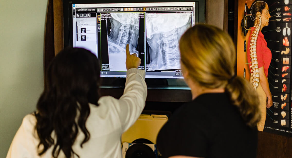 Chiropractor reviewing x-rays with patient