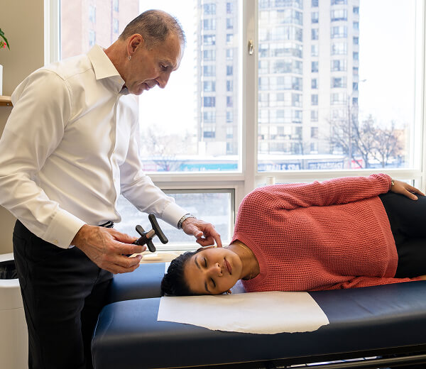 Dr. David Weyrauch adjusting female patient's neck