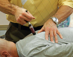 Dr. Weyrauch performs activator technique on patient.